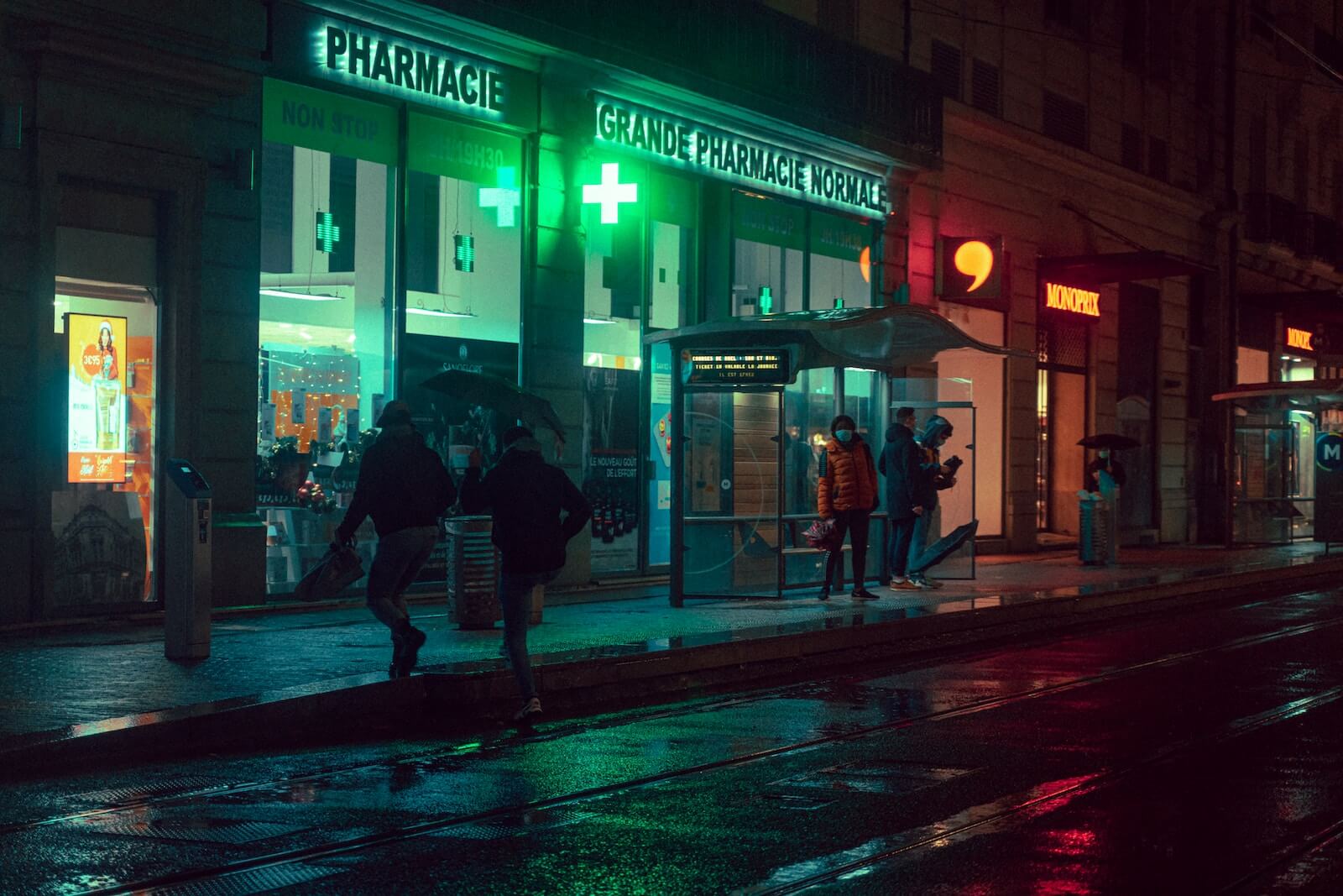 man and woman walking on sidewalk during night time